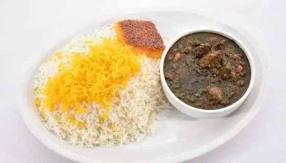 چلو قرمه‌سبزی لذیذ و اصیل ایرانی سرو شده در تهیه غذا و کترینگ پارسیا، همراه با برنج خوش‌عطر و زعفرانی و ته دیگ.