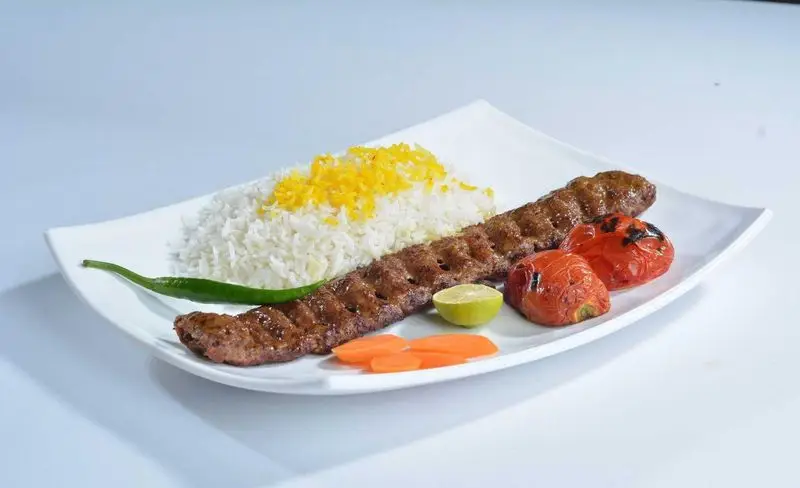 کباب کوبیده لذیذ به همراه چلو زعفرانی، گوجه کبابی، فلفل و لیمو از تهیه غذا و کترینگ پارسیا. غذای اصیل ایرانی.
