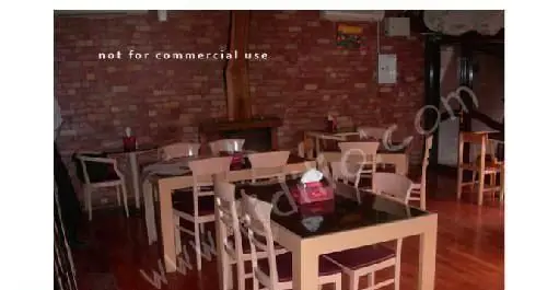 فضای داخلی رستوران ایتالیایی بوکا با میز و صندلی‌های چوبی و دیوارهای آجری، محیطی دلنشین برای صرف غذای لذیذ.