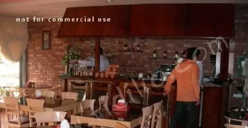 محیط داخلی دلنشین رستوران بوکا با دیوار آجری و بار شیک. آماده پذیرایی از مهمانان برای صرف انواع غذاهای ایتالیایی.