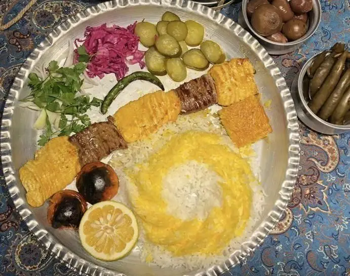 تصویری اشتهاآور از چلوکباب مجلسی رستوران مهدی، شامل کباب گوشت و جوجه، برنج زعفرانی و دورچین کامل. لذت غذای سنتی ایران.