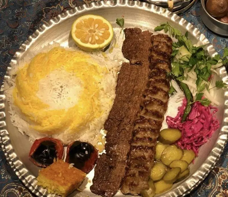 کباب کوبیده و برگ لذیذ رستوران مهدی با پلو زعفرانی، گوجه کبابی و مخلفات تازه، تجربه‌ای دلنشین از غذای اصیل ایرانی.
