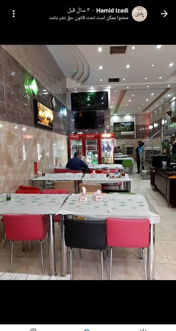 فضای داخلی روشن و مدرن کبابی لوکس نوروزی، محیطی تمیز با میز و صندلی‌های مرتب، دیوارهای مرمری و یخچال‌های نوشیدنی متنوع.