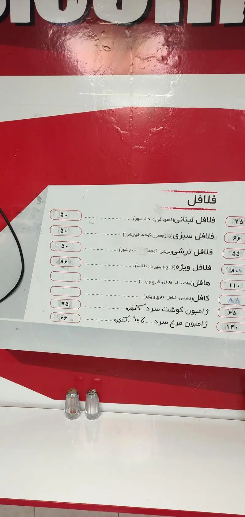 تصویری از منوی فلافل و ساندویچ منصور، شامل قیمت و جزئیات انواع فلافل (لبنانی، سبزی، ویژه)، هات داگ و ژامبون گوشت و مرغ سرد.