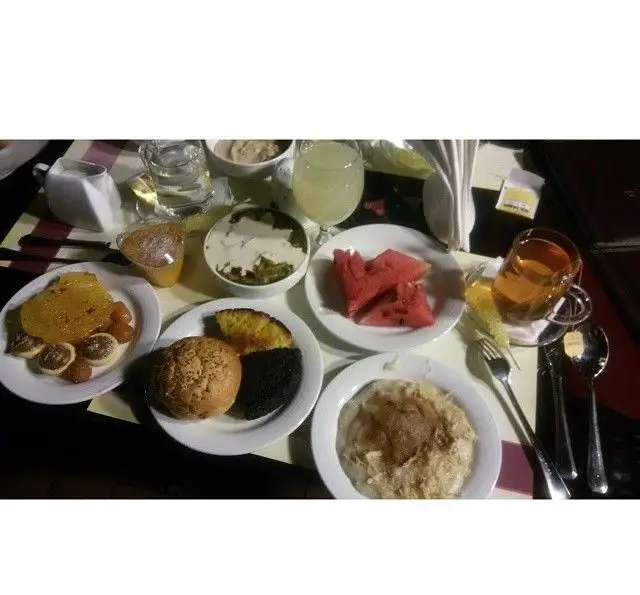 میز صبحانه و برانچ دلپذیر کافه رستوران کوهسار شامل شله زرد، نان و شیرینی تازه، هندوانه، حلیم، چای و آبمیوه طبیعی.