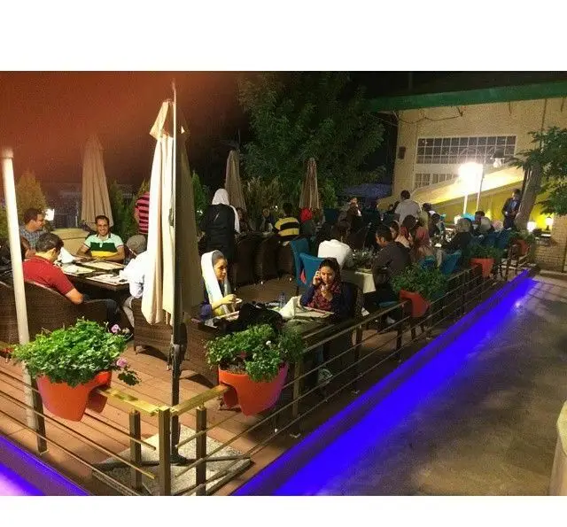 فضای دلنشین و سرزنده کافه رستوران کوهسار در شب، میزبان مشتریانی در حال صرف شام و نوشیدنی در محیطی دنج و نورانی.