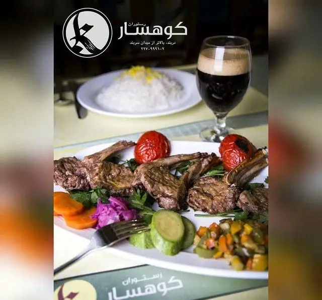 نمایی اشتهاآور از دنده کباب یا شیشلیک رستوران کوهسار با پلو، گوجه کبابی و مخلفات متنوع. تجربه غذای لذیذ در کافه رستوران کوهسار دربند تهران.