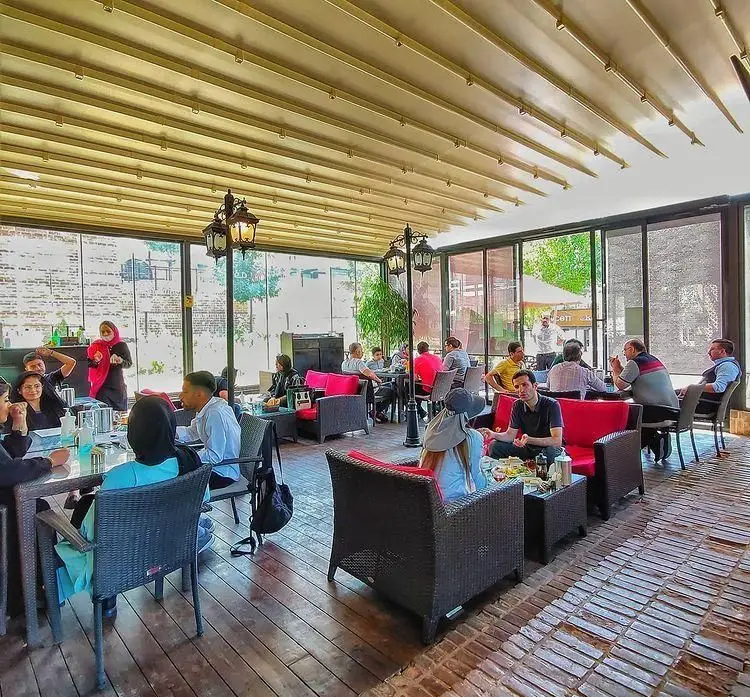 تصویری از ایلی کافه، فضایی شیک و دلنشین با سقف متحرک، مشتریان در حال لذت بردن از لحظات خوش و دورهمی های دوستانه.