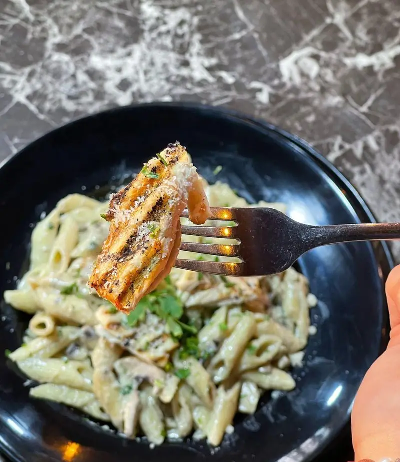 تجربه طعم بی نظیر پاستا پنه با مرغ گریل و سس خامه ای آلفردو و قارچ در باغ رستوران طبیعت، انتخابی عالی برای ناهار یا شام.