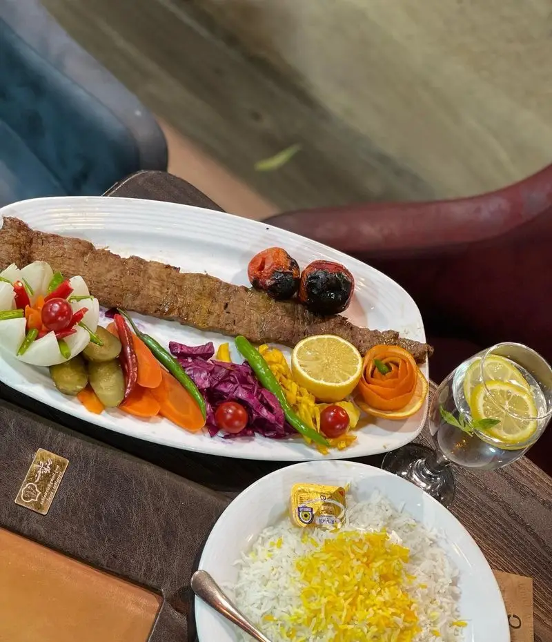 کباب کوبیده و برنج زعفرانی خوشمزه در باغ رستوران طبیعت. تجربه غذای اصیل ایرانی با محیطی دلنشین و خدماتی عالی.