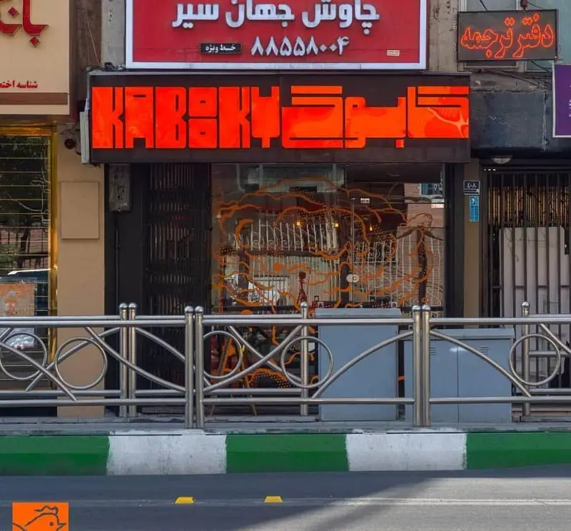 نمای بیرونی رستوران مرغ سوخاری کابوکی با تابلوی نئون درخشان "KABUKI"، آماده پذیرایی از مشتریان برای تجربه‌ی طعم بی‌نظیر.