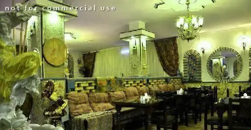 فضای داخلی سفره خانه سنتی مروارید با دکوراسیون زیبا و اصیل ایرانی، تخت‌های چوبی، میز و صندلی، آینه‌های تزئینی و لوستر مجلل، محیطی دلنشین و آرامش‌بخش برای پذیرایی