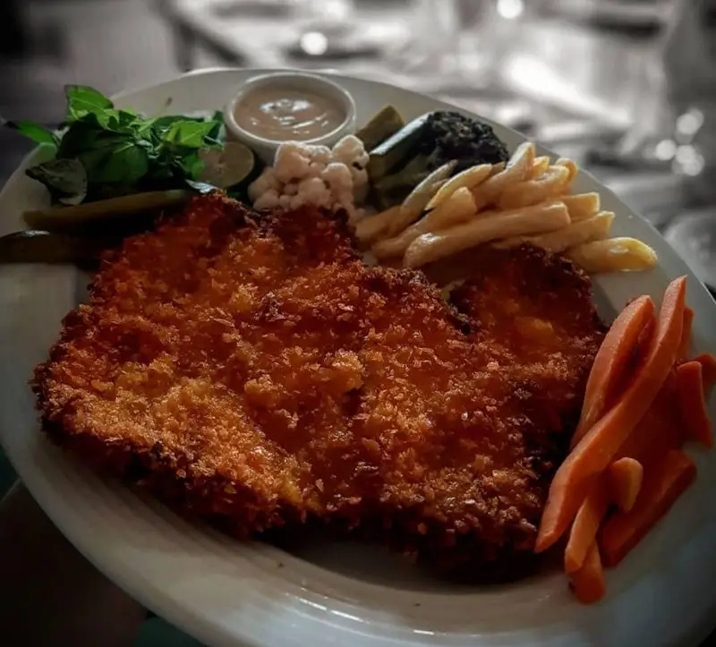 غذای سوخاری پیتزا میخوش: دو تکه شنیتسل مرغ ترد و طلایی با سیب‌زمینی سرخ‌کرده، هویج، سبزی تازه، ترشی و سس مخصوص.