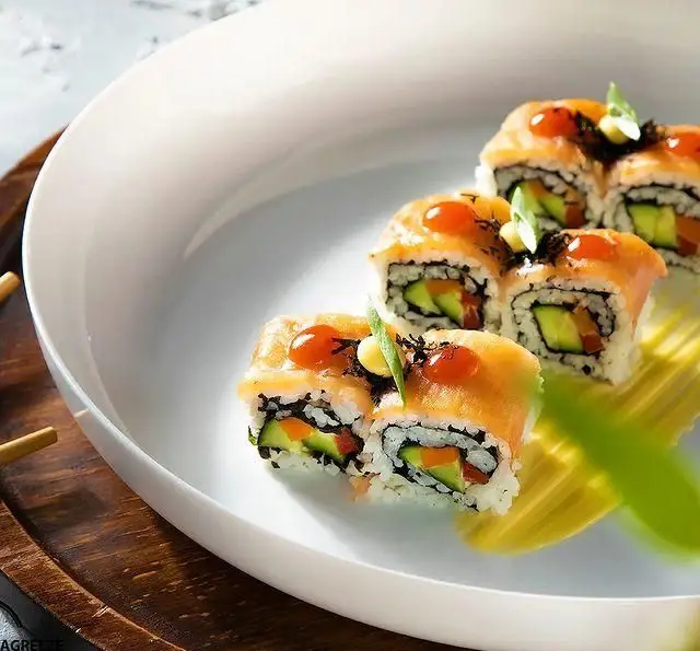 سوشی رول‌های سالمون و آووکادو با چاشنی‌های دلپذیر، در بشقابی شیک از کافه رستوران مگریز. تجربه‌ای لوکس و خاص از غذای ژاپنی.