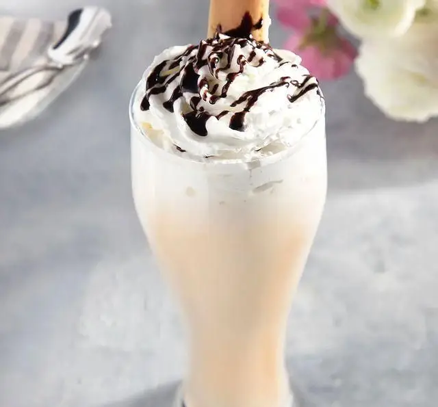 میلک شیک خامه ای جذاب با سس شکلات و ویفر، یک نوشیدنی خنک و دلپذیر از منوی ویژه کافه رستوران مگریز.