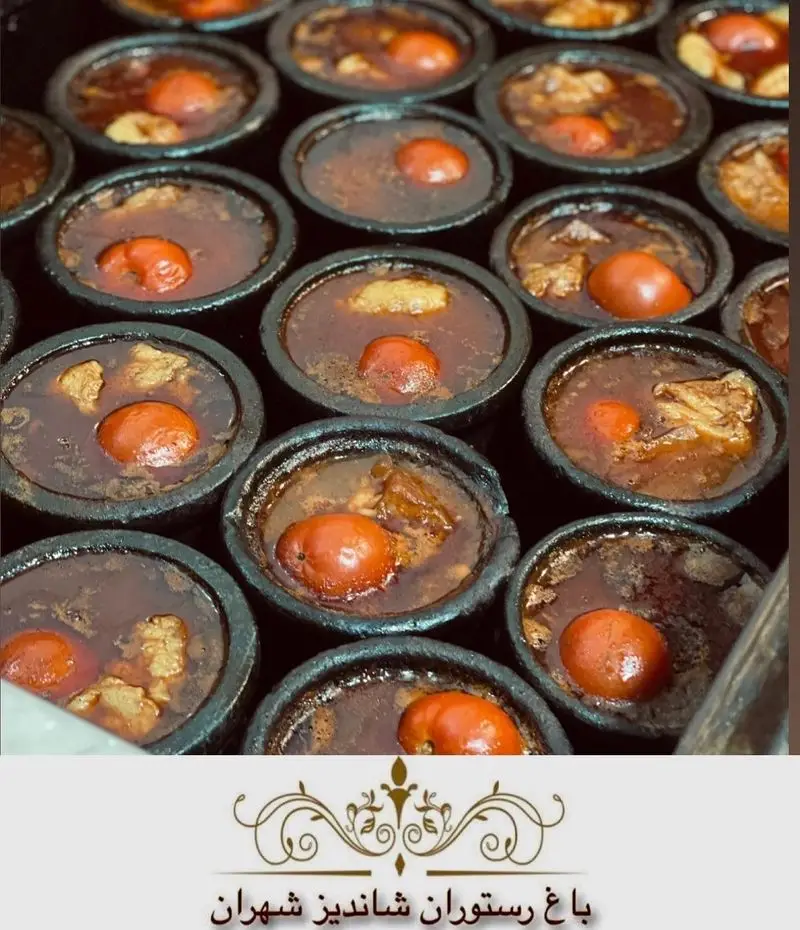 تصویری جذاب از دیزی یا آبگوشت سنتی و لذیذ ایرانی در ظروف سفالی مخصوص، آماده سرو در باغ رستوران شاندیز تهران.