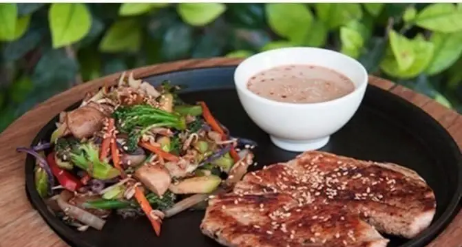 غذای سالم رستوران واسابی: مرغ گریل با سبزیجات متنوع آسیایی تفت داده شده و سس بادام زمینی در بشقاب داغ. انتخابی عالی برای ناهار یا شام.