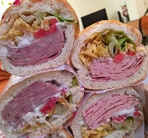 چندین ساندویچ هایدا پرملات و خوشمزه کالباس و ژامبون، با سس مخصوص، کاهو، گوجه و چیپس خلالی در نان باگت، آماده سرو.