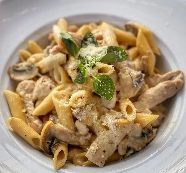 پاستا پنه مرغ و قارچ با سس خامه ای، پنیر پارمزان و ریحان تازه. غذای لذیذ کافه رستوران دریا باز، انتخابی عالی برای شما.