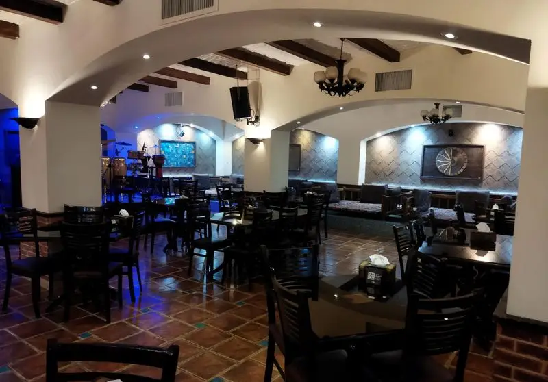 نمایی از فضای داخلی رستوران سنتی عمارت، شامل میز و صندلی، دکوراسیون سنتی با طاق‌های زیبا و نورپردازی گرم و دلنشین.