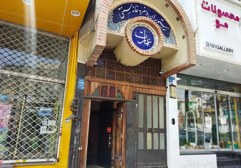 ورودی جذاب رستوران و سفره خانه سنتی عمارت با کاشی‌کاری چشم‌نواز و درب چوبی قدیمی، مکانی برای تجربه‌ی اصیل.