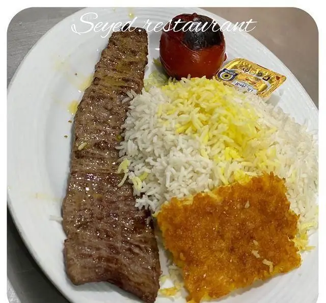 تصویر غذای کباب برگ یا کوبیده رستوران سید در شهرری، شامل برنج، ته دیگ، گوجه کبابی و کره. تجربه‌ی غذای اصیل ایرانی.