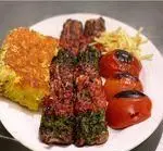 کباب‌های رنگارنگ و ته چین زعفرانی رستوران سید در شهر ری، همراه با گوجه کبابی و سیب زمینی سرخ شده، تجربه‌ای لذت‌بخش از غذای ایرانی.