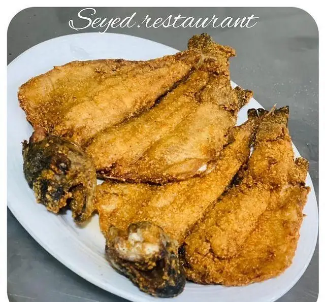 تصویری از چندین تکه ماهی سرخ شده و خوشمزه در بشقاب سفید از رستوران سید شهرری، مناسب برای غذای دریایی باکیفیت و اصیل.