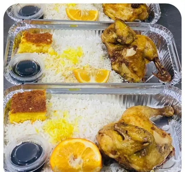 چلو مرغ مجلسی رستوران سید شهرری با برنج زعفرانی، ته چین، سس مخصوص و برش پرتقال در ظروف آلومینیومی.