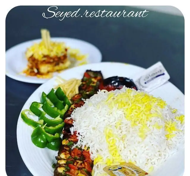 غذای ایرانی اصیل: چلو کباب مجلسی با برنج زعفرانی، سبزیجات تازه، گوجه و فلفل کبابی در رستوران سید شهرری.