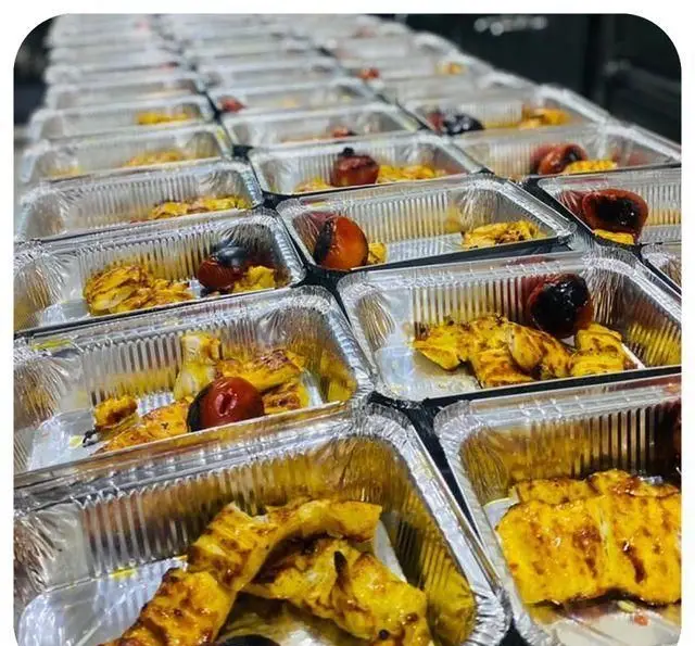 مجموعه ای از ظروف آلومینیومی حاوی کباب جوجه خوش طعم و گوجه کبابی رستوران سید شهرری برای سرویس بیرون بر آماده شده‌اند.