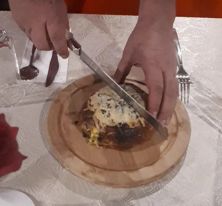 یک غذای ویژه و داغ با روکش پنیر ذوب‌شده در رستوران پرشین گلف توسط مشتری برش می‌خورد. طعمی فراموش‌نشدنی و تجربه‌ای عالی.