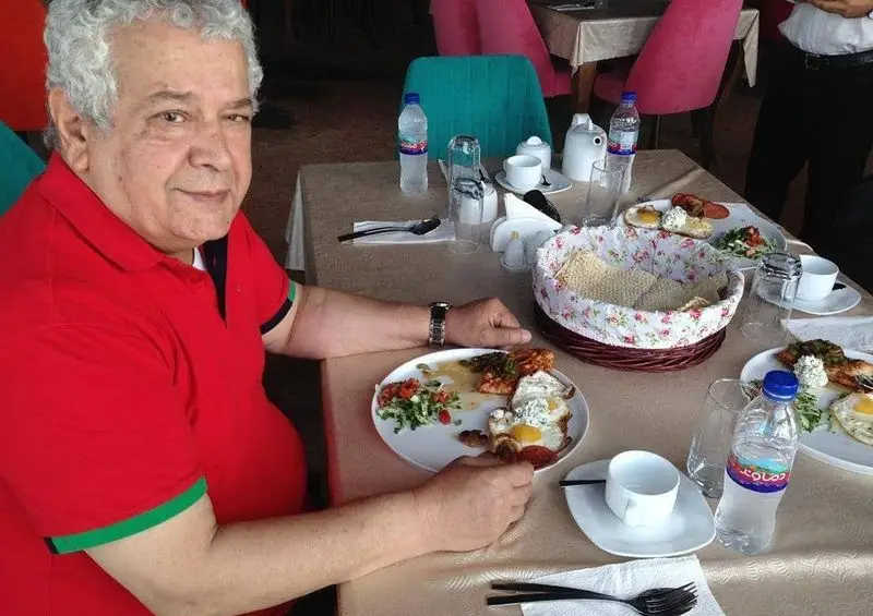 مشتری میانسال در رستوران پرشین گلف، از میز صبحانه خود با غذاهای لذیذ و نان سنتی لذت می‌برد. تجربه‌ای به یادماندنی.