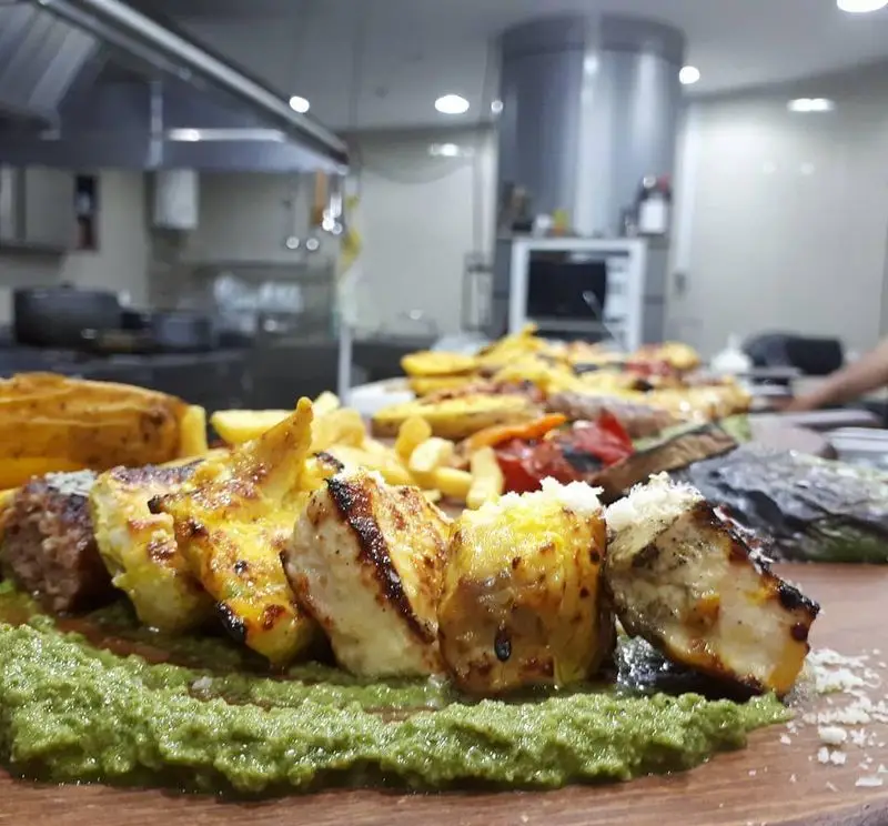 سینی کباب و گریل رستوران پرشین گلف: جوجه کباب، کوفته، سس سبز، سیب زمینی سرخ کرده و سبزیجات گریل شده آماده سرو.