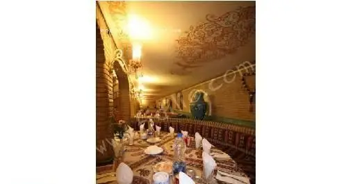 تصویری از فضای داخلی رستوران سنتی ایرانی عالی قاپو با دکوراسیون دلنشین، میزهای چیده شده و طراحی اصیل.