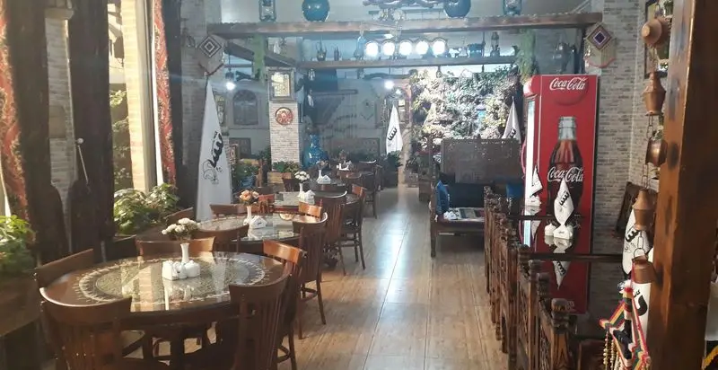فضای داخلی دلنشین کافه و رستوران سنتی سپه با دکوراسیون ایرانی اصیل، میز و صندلی‌های چوبی، تزئینات بومی و محیطی گرم و آرام برای میزبانی مهمانان.