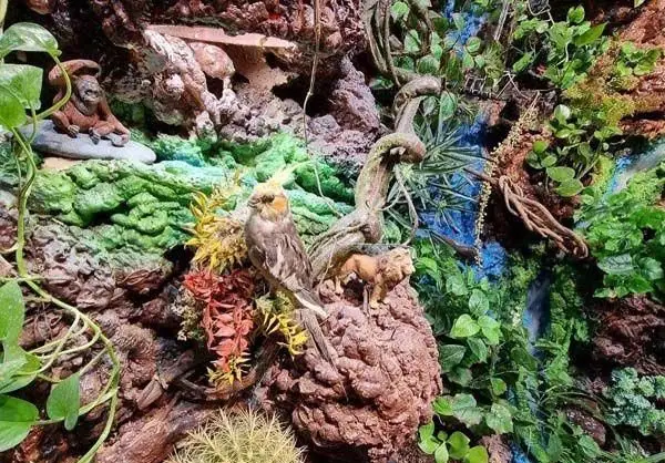 دکوراسیون زیبا و طبیعت‌گرای کافه و رستوران سنتی سپه با مجسمه‌های پرنده، شیر و اورانگوتان در محیطی سرسبز و دلنشین.