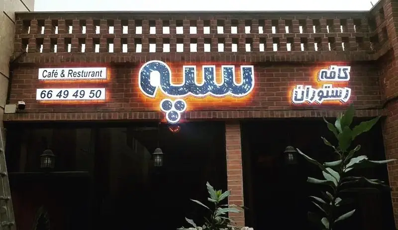 نمای بیرونی کافه و رستوران سنتی سپه. تابلوی کافه و رستوران سنتی 'سپه' با حروف درخشان، به همراه شماره تماس 66494950 برای رزرو.