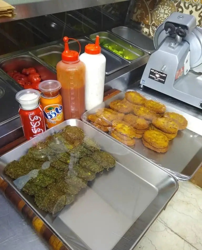 فضای داخلی ساندویچ شاپ مزه فرنگ با سینی‌های فلافل طلایی، کتلت سبزیجات، سس‌های متنوع و مخلفات تازه برای ساندویچ‌های خاص.