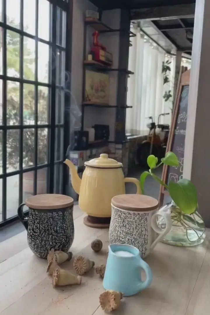 فضای دنج و دلنشین کافه رستوران پلاک ٥ با قوری زرد چای داغ و ماگ‌های طرح‌دار، محیطی ایده‌آل برای نوشیدنی‌های گرم و لحظات آرامش‌بخش.