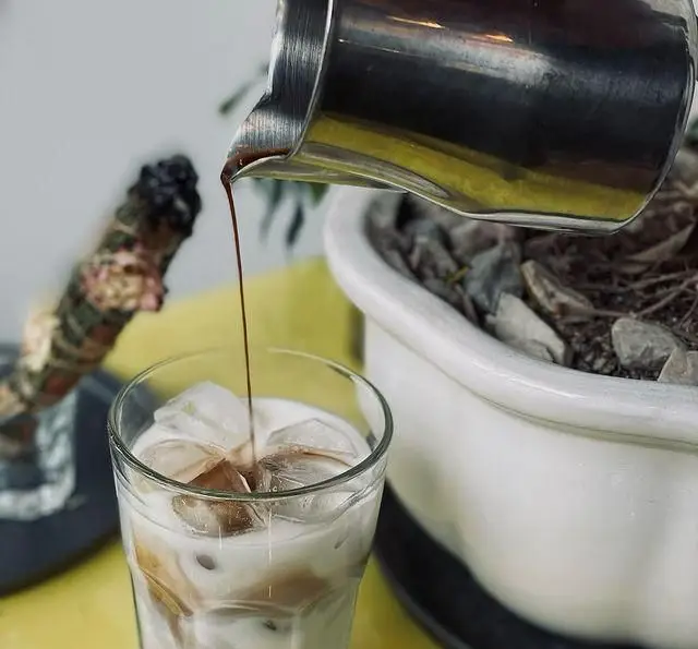 نمایی از تهیه نوشیدنی محبوب آیس لاته در کافه رستوران پلاک ٥. قهوه تیره روی شیر و یخ، تجربه‌ای متفاوت در پلاک ٥.