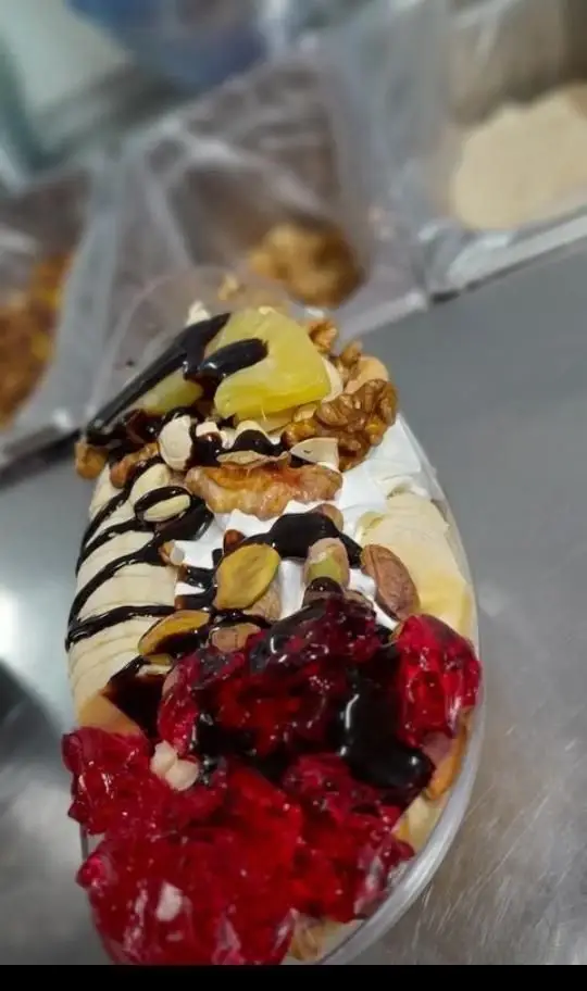دسر میوه ای ویژه بستنی ناصر؛ ترکیبی جذاب از موز، خامه، ژله قرمز، تکه های آناناس، مغزهای تازه پسته و گردو با سس شکلات.
