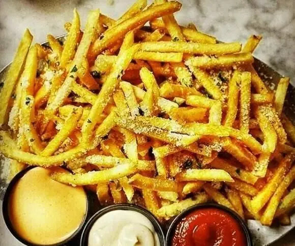 سیب‌زمینی سرخ کرده داغ و ترد با پنیر پارمسان و سبزیجات معطر، همراه با سس‌های متنوع، انتخابی خوشمزه از پیتزا تام.