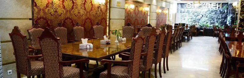 تصویری از سالن غذاخوری مجلل کافه رستوران ارکیده شعبه آرژانتین با دکوراسیون سلطنتی، میز و صندلی‌های چوبی نفیس و دیوارنگاره طبیعت.