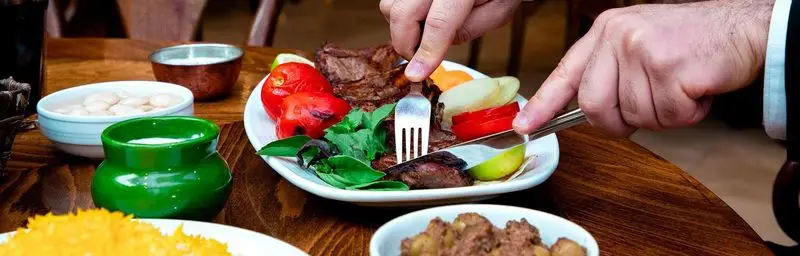 مشتری در حال لذت بردن از کباب لذیذ و غذاهای اصیل ایرانی با برنج و مخلفات در محیط دلنشین کافه رستوران ارکیده شعبه آرژانتین.