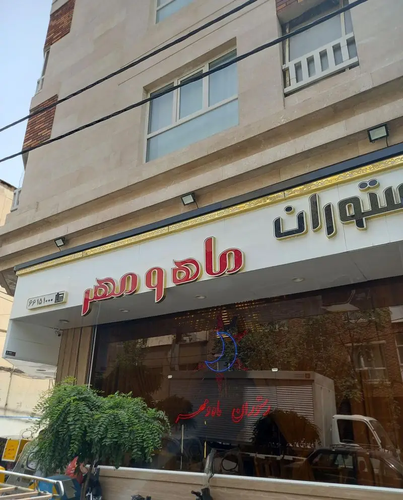 نمای بیرونی رستوران ماه و مهر، با تابلوی روشن و شماره تلفن ۶۶۱۵۱۰۰۰. مکانی دنج برای لذت بردن از غذاهای ایرانی و سنتی.