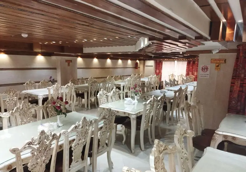 فضای داخلی مجلل رستوران ماه و مهر، دارای سالن غذاخوری وسیع با میز و صندلی‌های سفید حکاکی‌شده و دکوراسیون گرم و دلنشین.