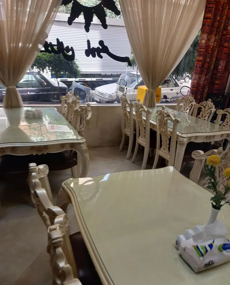 فضای داخلی لوکس و دنج رستوران ماه و مهر با دکوراسیون کلاسیک، میز و صندلی‌های مجلل و پرده‌های زیبا. مناسب برای سرو انواع غذا.