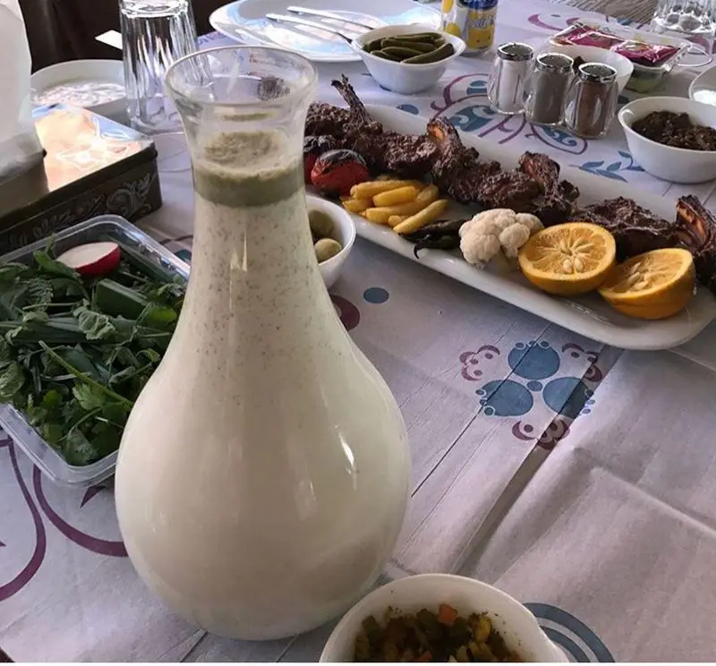 غذای خوشمزه در رستوران ماه و مهر: کباب بره آبدار، دوغ سنتی، سبزی تازه، سیب‌زمینی سرخ کرده و مخلفات متنوع میز ایرانی.