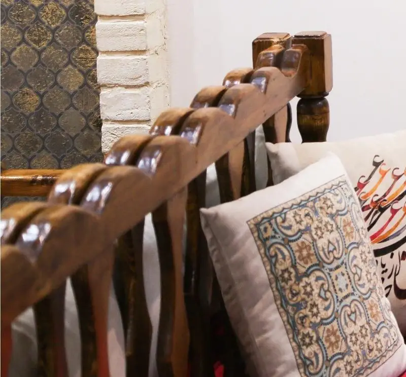 دکوراسیون سنتی و دلنشین رستوران خوان کرم با تخت چوبی و بالشت‌های طرح‌دار، فضایی اصیل و آرامش‌بخش برای میهمانان فراهم کرده است.